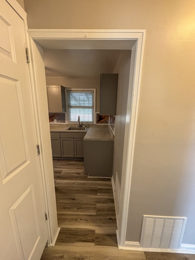 18484 Ashton Ave, Detroit, MI 48219 - hallway featuring dark wood-type flooring, a sink, and visible vents