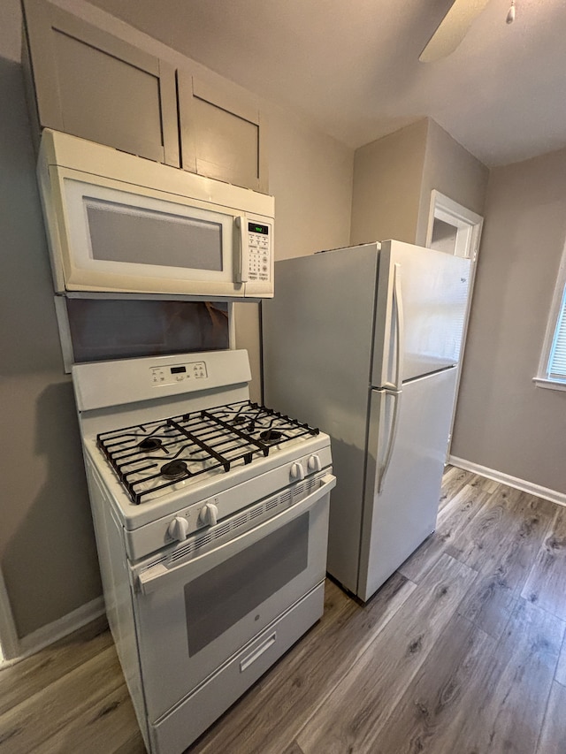 18484 Ashton Ave, Detroit, MI 48219 - kitchen with white appliances, baseboards, a ceiling fan, and wood finished floors