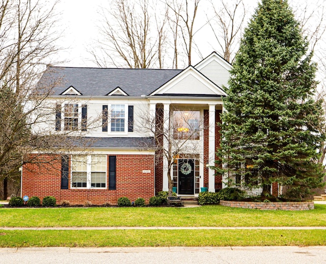 view of front of property featuring brick siding and a front lawn