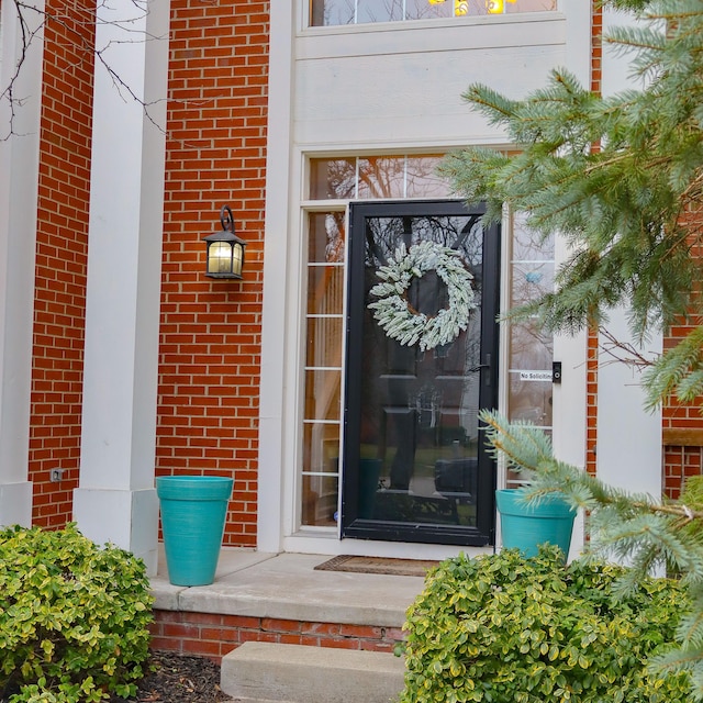 view of exterior entry with brick siding