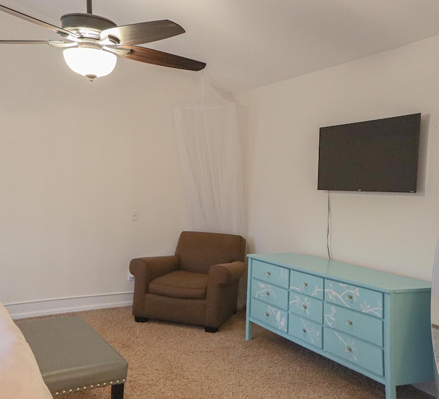 sitting room featuring baseboards, ceiling fan, and carpet