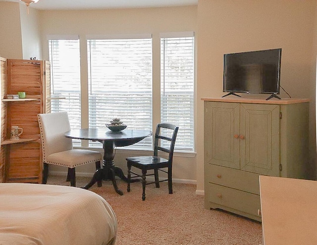 bedroom featuring light carpet and baseboards