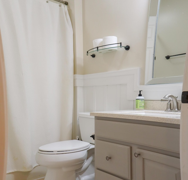 bathroom featuring toilet, vanity, and a shower with shower curtain
