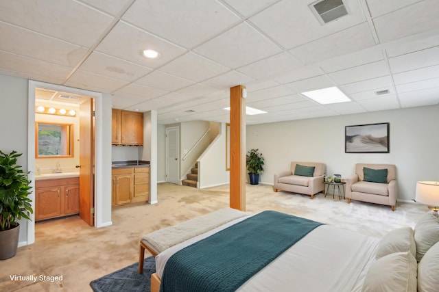 bedroom featuring visible vents, baseboards, a paneled ceiling, connected bathroom, and light carpet