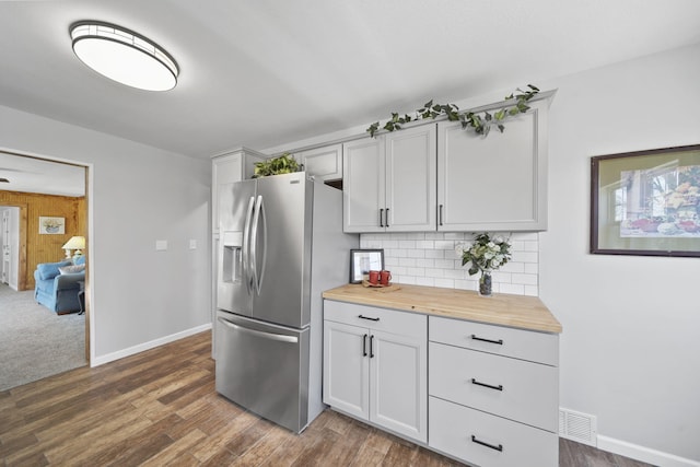 kitchen featuring decorative backsplash, dark wood-style flooring, visible vents, wooden counters, and stainless steel fridge with ice dispenser