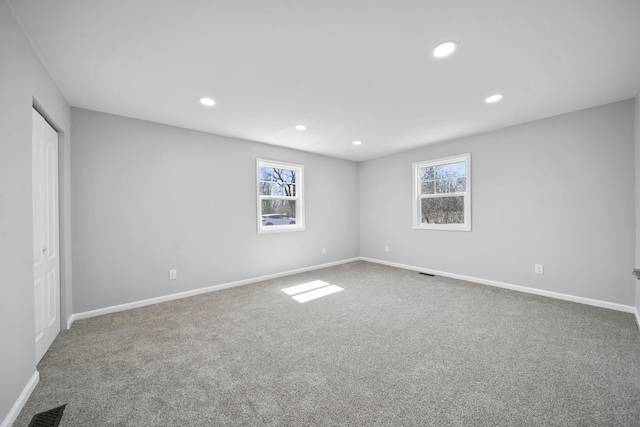 spare room featuring baseboards, visible vents, recessed lighting, and a healthy amount of sunlight
