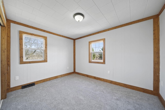carpeted spare room with baseboards and visible vents
