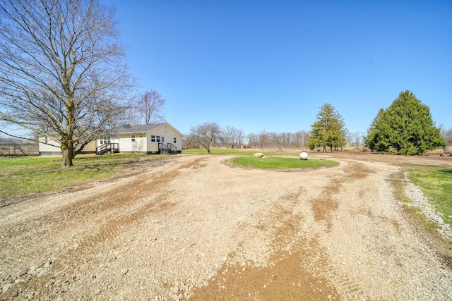 view of road featuring dirt driveway