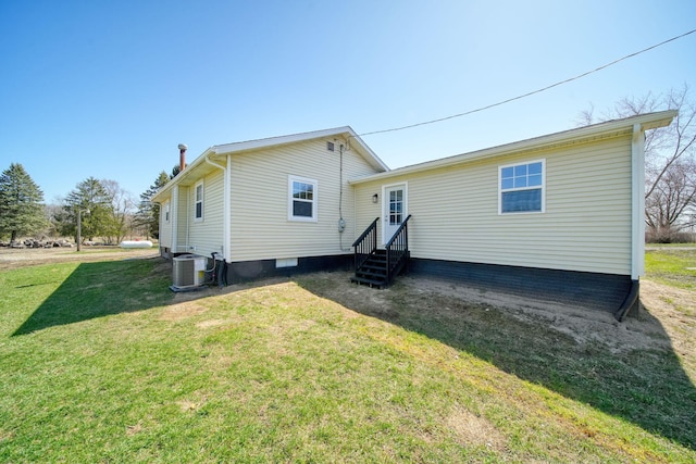 back of house featuring a lawn, cooling unit, and entry steps