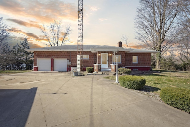 140 32nd St, Allegan, MI 49010 - ranch-style house featuring a chimney, a garage, a lawn, brick siding, and driveway