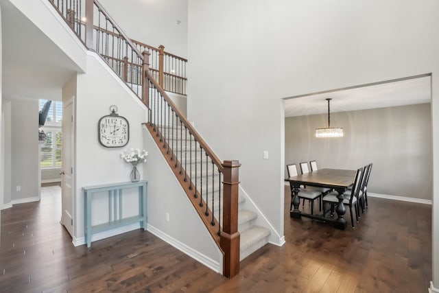 7416 Secretariat Dr, Saline, MI 48176 - staircase featuring a chandelier, a high ceiling, baseboards, and wood finished floors
