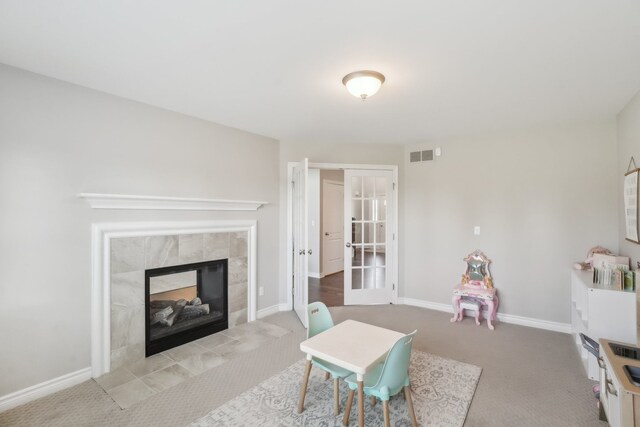 7416 Secretariat Dr, Saline, MI 48176 - rec room with baseboards, a tiled fireplace, french doors, visible vents, and carpet