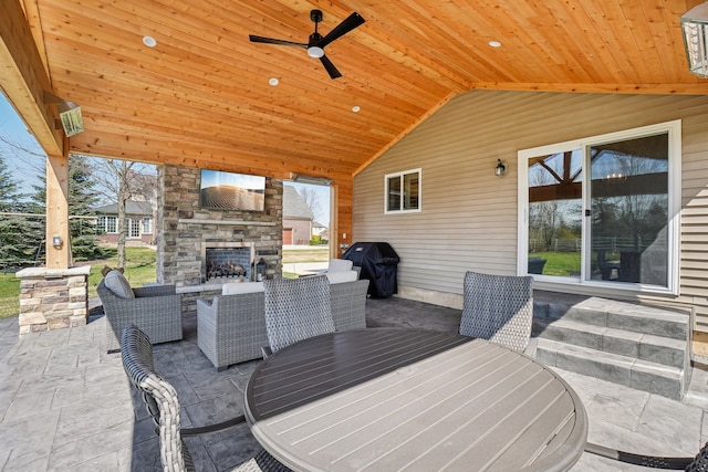 7416 Secretariat Dr, Saline, MI 48176 - view of patio / terrace with area for grilling, outdoor dining space, a ceiling fan, and an outdoor stone fireplace