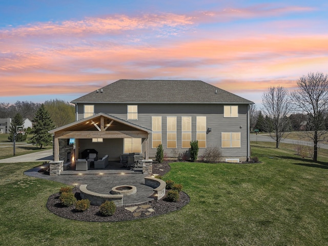 7416 Secretariat Dr, Saline, MI 48176 - back of property at dusk featuring a patio, roof with shingles, driveway, an outdoor living space with a fire pit, and a lawn