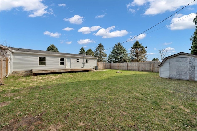 view of yard with a fenced backyard, a shed, a deck, and an outdoor structure