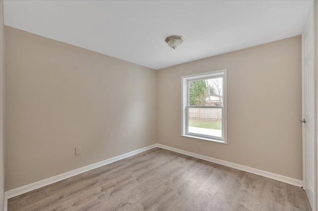 spare room featuring light wood-style floors and baseboards