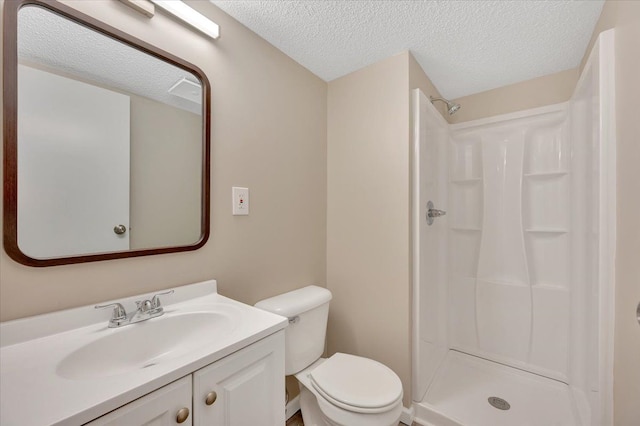 full bath featuring toilet, vanity, a stall shower, and a textured ceiling
