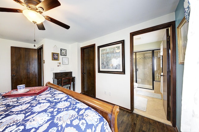 bedroom with a closet, baseboards, connected bathroom, wood finished floors, and ceiling fan