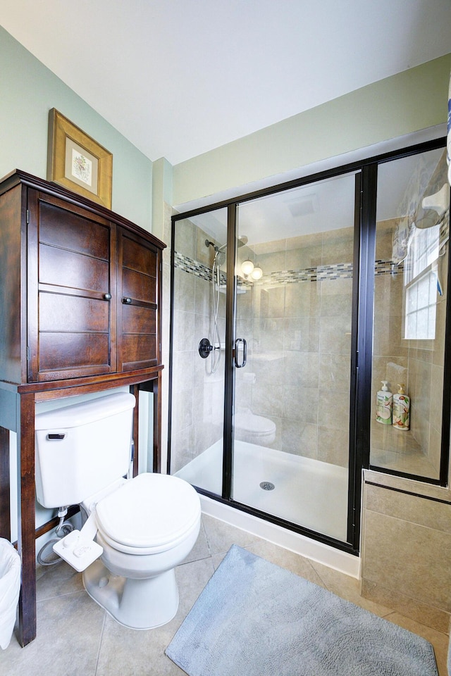 full bath with a shower stall, tile patterned floors, and toilet