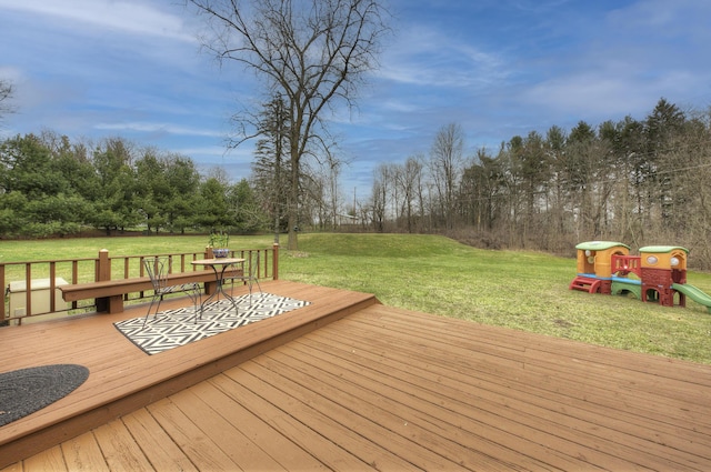 deck featuring playground community and a lawn