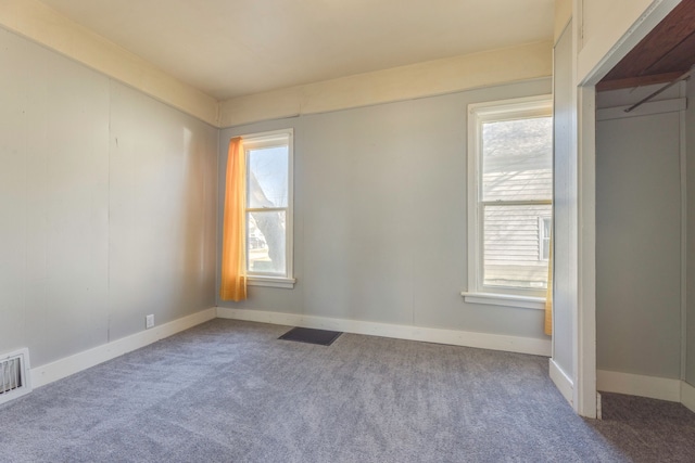 carpeted spare room with baseboards and visible vents