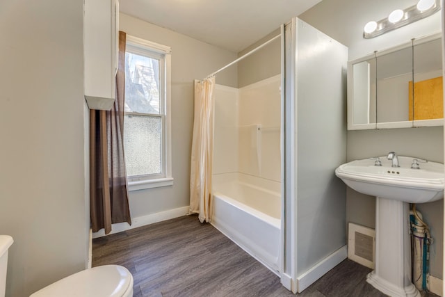 full bathroom with wood finished floors, visible vents, toilet, baseboards, and shower / tub combo