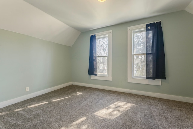 additional living space with vaulted ceiling, carpet floors, and baseboards