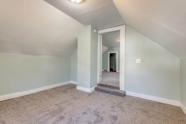 additional living space featuring lofted ceiling, baseboards, visible vents, and carpet