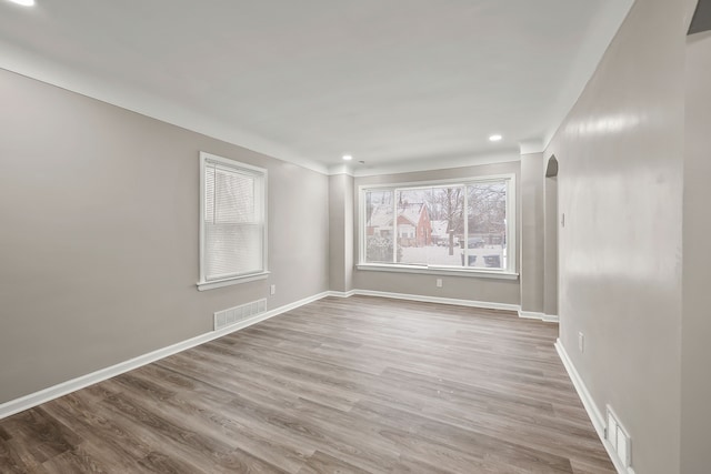 unfurnished room with baseboards, visible vents, wood finished floors, and recessed lighting