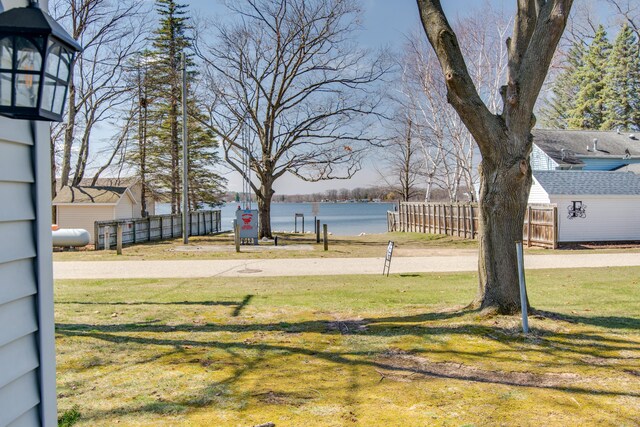 view of yard with a water view and fence