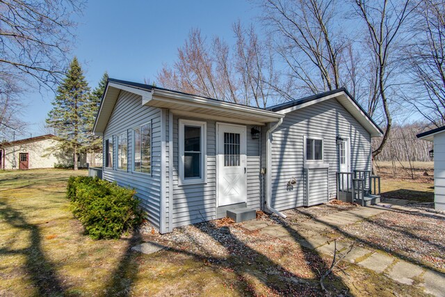 exterior space featuring a lawn and entry steps