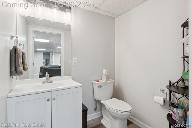 328 Split Rail Rdg, Williamston, MI 48895 - half bath featuring vanity, toilet, a drop ceiling, and baseboards