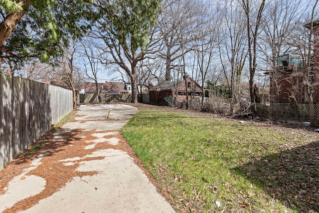view of yard with fence and driveway