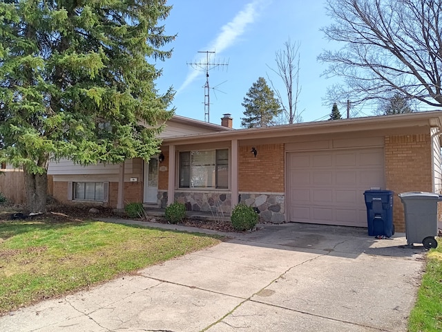 3508 Easthampton Dr, Flint, MI 48503 - split level home featuring driveway, brick siding, a front yard, and a garage