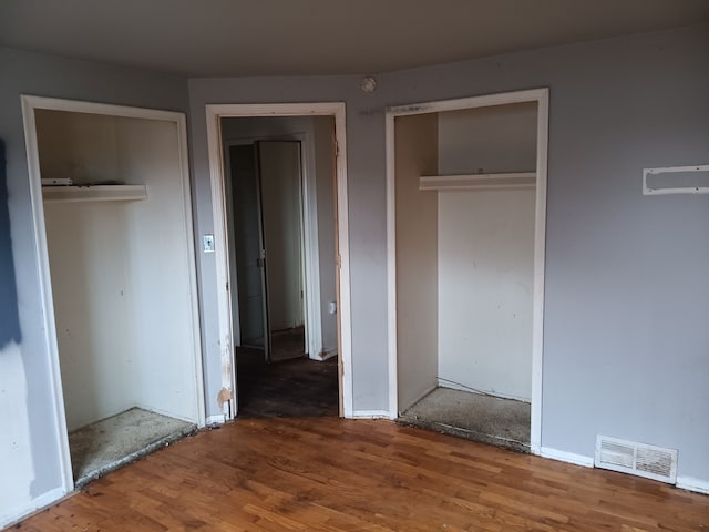 3508 Easthampton Dr, Flint, MI 48503 - unfurnished bedroom with wood finished floors, visible vents, and two closets