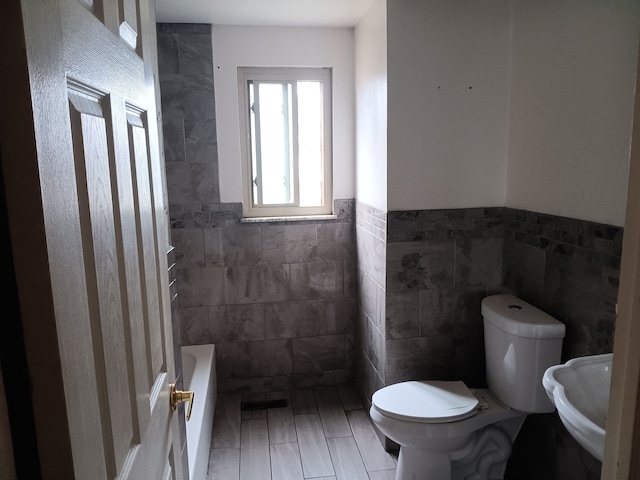 3508 Easthampton Dr, Flint, MI 48503 - full bathroom with tile walls, toilet, and wainscoting