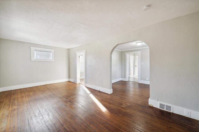 20035 Santa Barbara Dr, Detroit, MI 48221 - empty room with a textured ceiling, visible vents, baseboards, arched walkways, and wood-type flooring