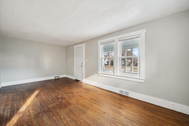 20035 Santa Barbara Dr, Detroit, MI 48221 - unfurnished room with dark wood-style flooring, a textured ceiling, baseboards, and visible vents