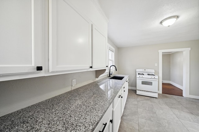 20035 Santa Barbara Dr, Detroit, MI 48221 - kitchen with white gas stove, baseboards, a sink, light stone counters, and white cabinets
