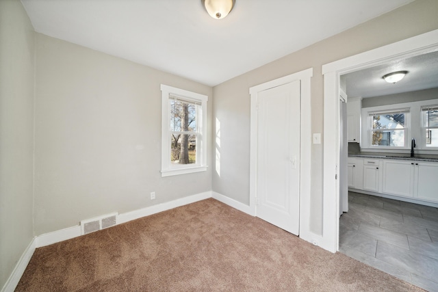 20035 Santa Barbara Dr, Detroit, MI 48221 - unfurnished bedroom featuring multiple windows, visible vents, carpet, and a sink