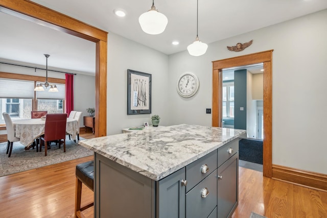 kitchen featuring gray cabinetry, light wood-style flooring, hanging light fixtures, and plenty of natural light