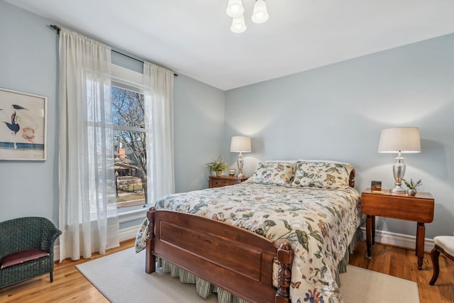 bedroom with baseboards and wood finished floors