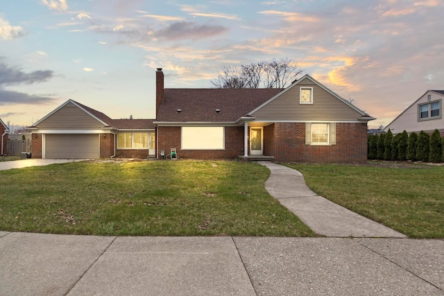 view of front of house featuring a front yard, an attached garage, a chimney, brick siding, and driveway