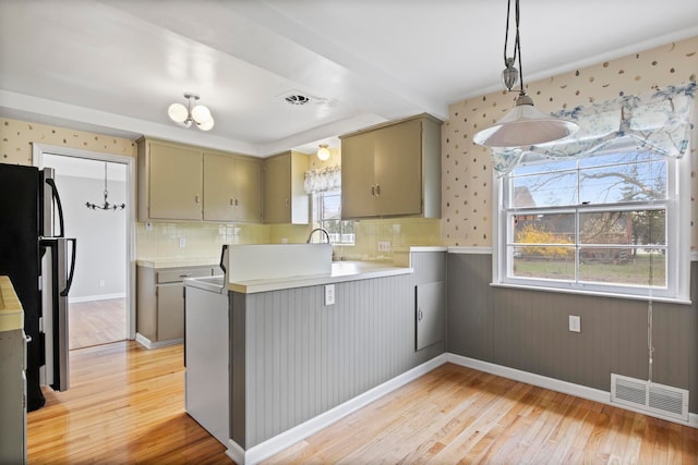 kitchen featuring a peninsula, visible vents, freestanding refrigerator, and light wood-style flooring