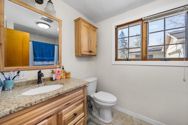bathroom featuring tile patterned flooring, vanity, toilet, baseboards, and visible vents