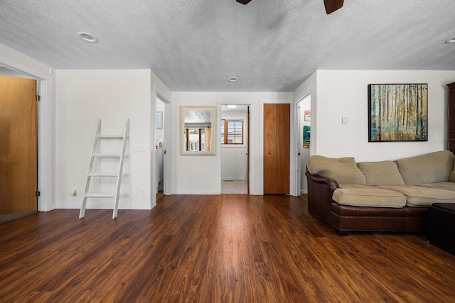 living area with wood finished floors, a textured ceiling, baseboards, and ceiling fan