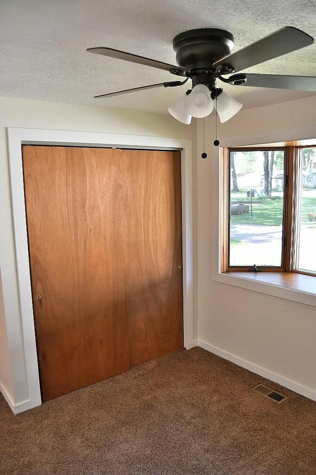 unfurnished bedroom featuring visible vents, a closet, carpet floors, and a textured ceiling