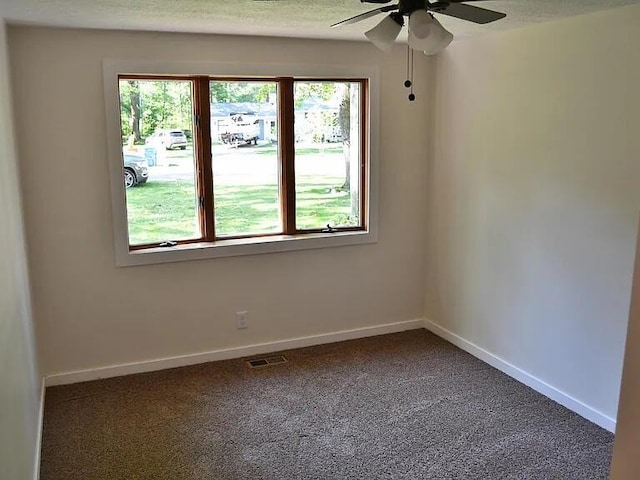 carpeted spare room with baseboards, visible vents, a textured ceiling, and a ceiling fan