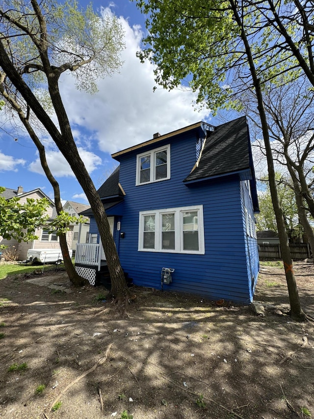 view of front of home with fence and roof with shingles