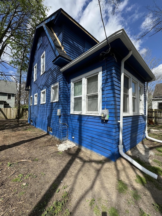 view of side of home featuring fence
